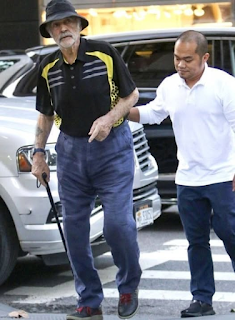 Kan du gissa vem det här är? Den här legendariska skådespelaren, som syns promenerande i New York, ser märkbart skör ut vid 87 års ålder. Han var en gång hyllad för sin enorma karisma, styrka och ikoniska filmroller, och fansen slås av hur tiden förändrar även de mest uthålliga Hollywoodstjärnorna. Känner du igen honom? Kolla den översta kommentaren för att avslöja svaret!